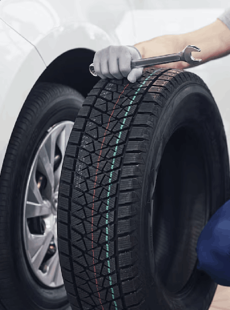 Technician with a blue workwear, holding a wrench and a tire while showing thumb up Technician with a blue workwear, holding a wrench and a tire while showing thumb up<br />